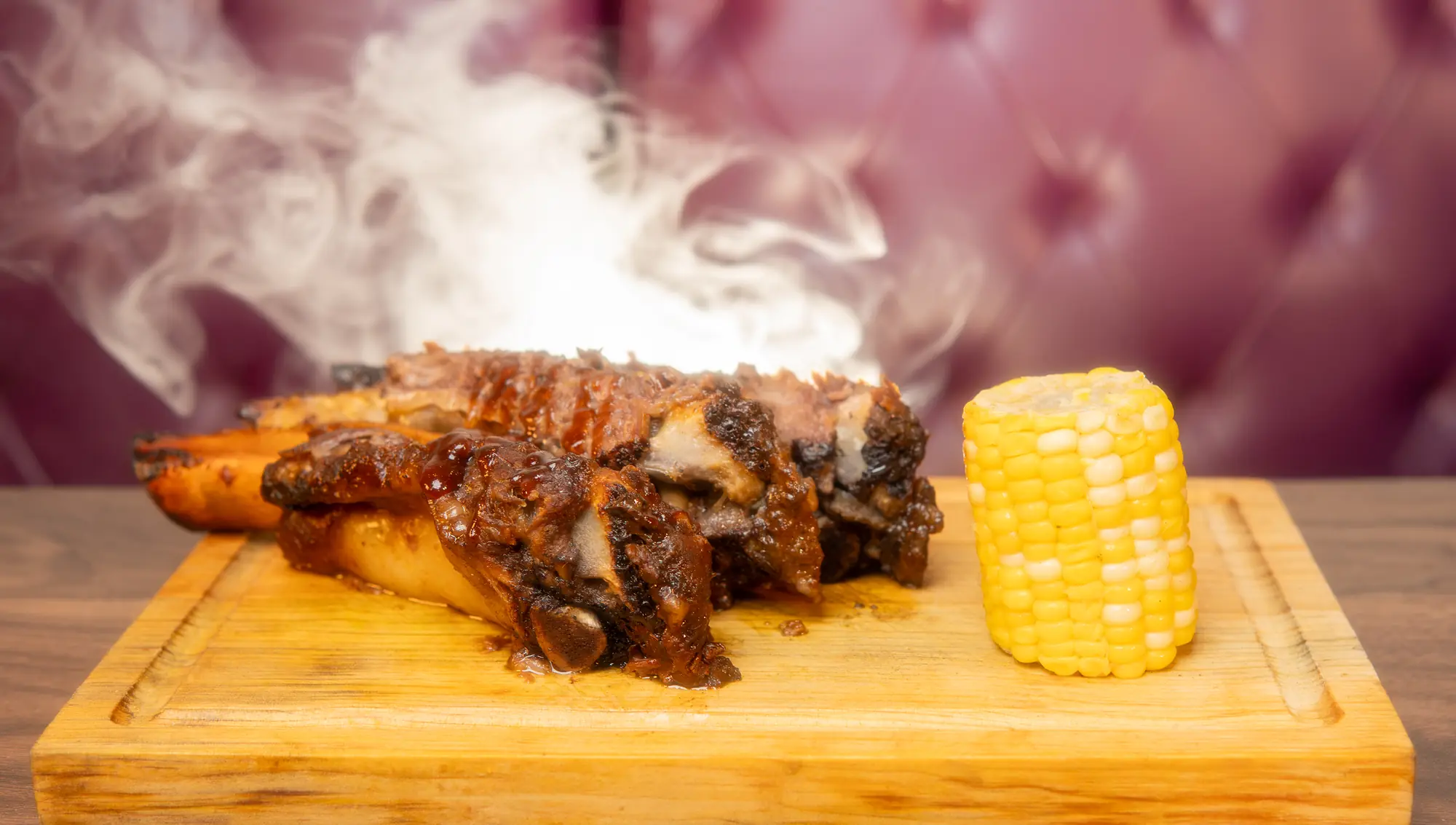 Costillas de res BBQ recién salidas del ahumador, todavía humeando